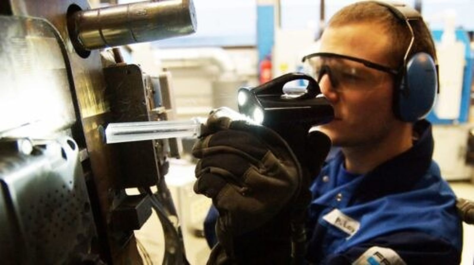 Operario con gafas y protección auditiva limpiando un molde de fundición con una pistola de hielo seco Cold Jet