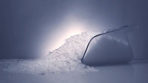 Pellets de hielo seco en una pala sobre fondo oscuro